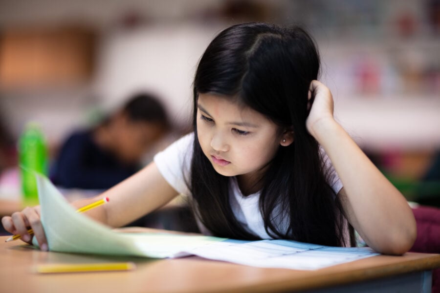 A pupil concentrating over her paper in a Test Teach class